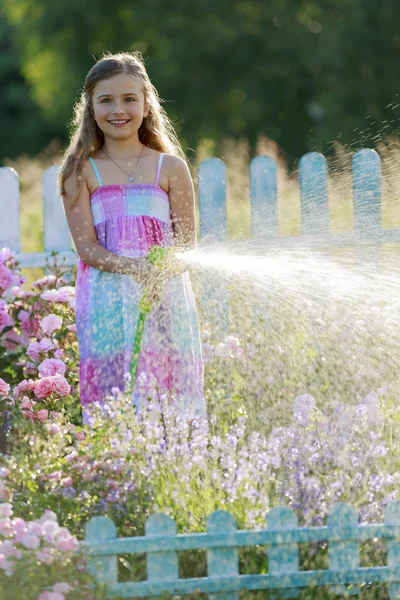 Bewässerung, Blumengarten - schönes Mädchen, das Rosen gießt — Stockfoto