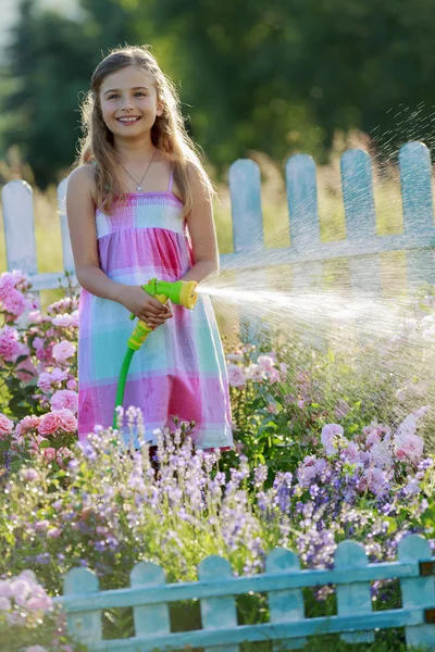 Riego, jardín de flores - hermosa niña regar rosas —  Fotos de Stock
