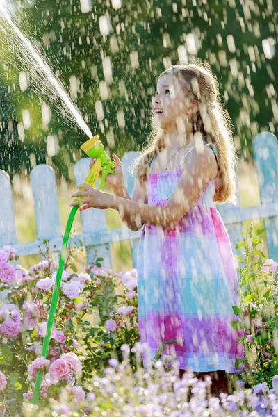 De pret van de zomer, meisje drenken bloemen — Stockfoto