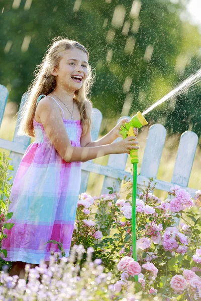 Summer fun, lovely girl watering flowers — Stock Photo, Image
