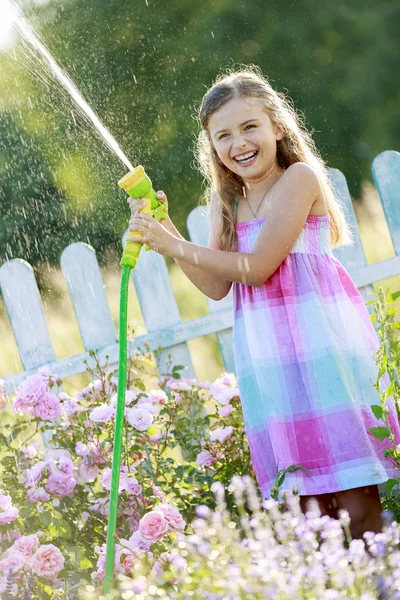 Verão divertido, linda menina regando flores — Fotografia de Stock