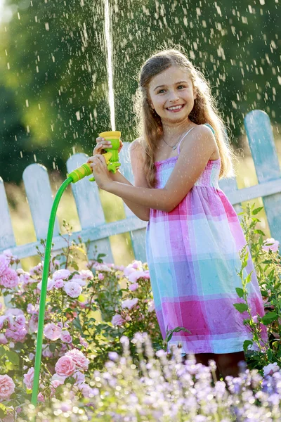 Verão divertido, linda menina regando flores — Fotografia de Stock