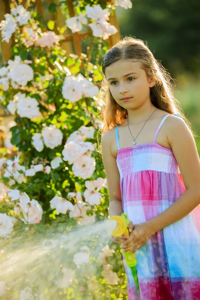 Diversão do verão, flores molhando da menina — Fotografia de Stock