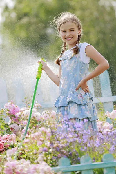 Diversão do verão, flores molhando da menina — Fotografia de Stock