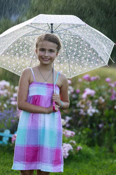 Sommarregn - glad tjej med ett paraply i regnet — Stockfoto