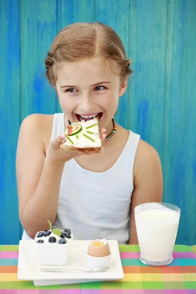 Sommerfrühstück - süßes Mädchen isst gesundes Frühstück — Stockfoto