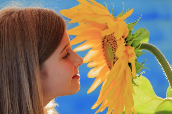 Girl and sunflower - beautiful girl is smelling sunflower — Stock Photo, Image
