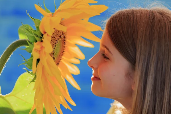Flicka och solros - vacker flicka är att lukta solros — Stockfoto