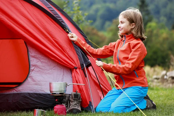 Läger i tältet - ung flicka inställning ett tält på campingen — Stockfoto
