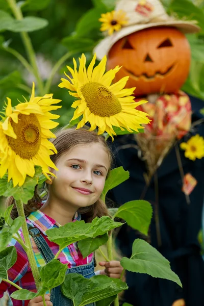 Scarecrow en blij meisje in de tuin — Stockfoto