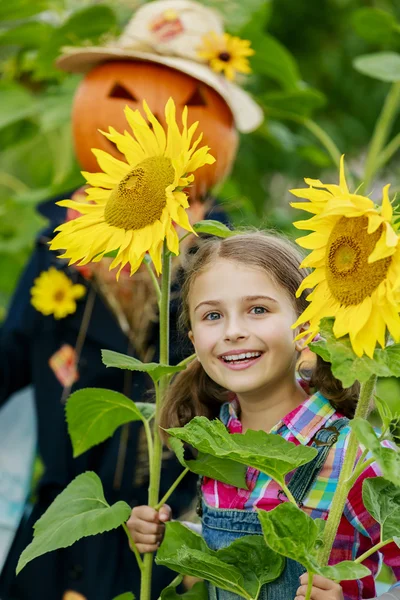 Espantapájaros y chica feliz en el jardín —  Fotos de Stock