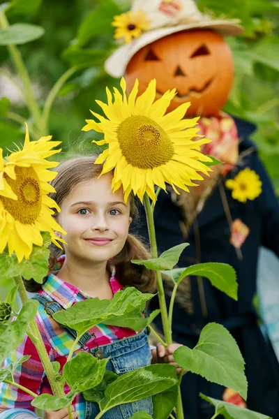 Espantalho e menina feliz no jardim — Fotografia de Stock