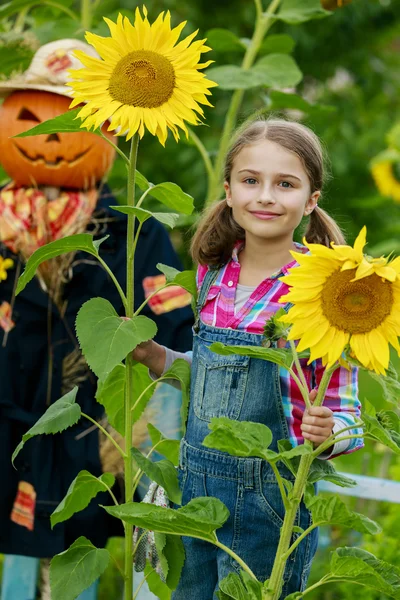 Espantapájaros y chica feliz en el jardín —  Fotos de Stock