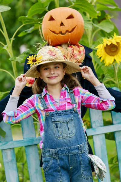 Espantalho e menina feliz no jardim — Fotografia de Stock