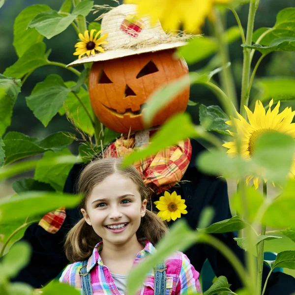 Espantalho e menina feliz no jardim — Fotografia de Stock