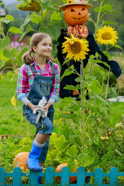 Пугало и счастливая девушка в саду — стоковое фото