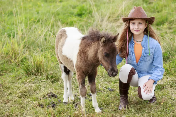 Lilla föl och tjej - söt tjej tar hand om ponny föl — Stock fotografie