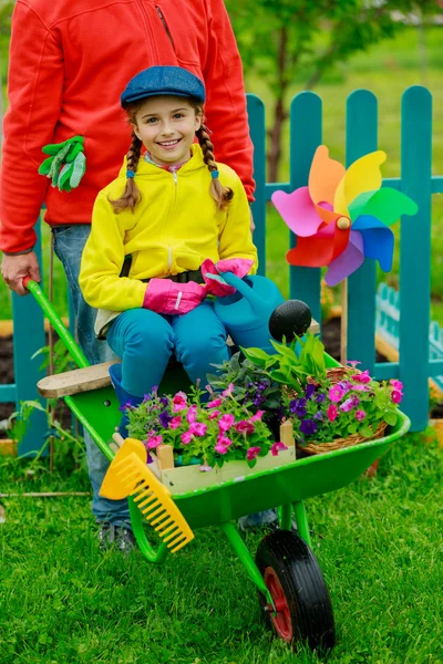 Jardinagem, plantio - menina no carrinho de mão ajudando pai — Fotografia de Stock