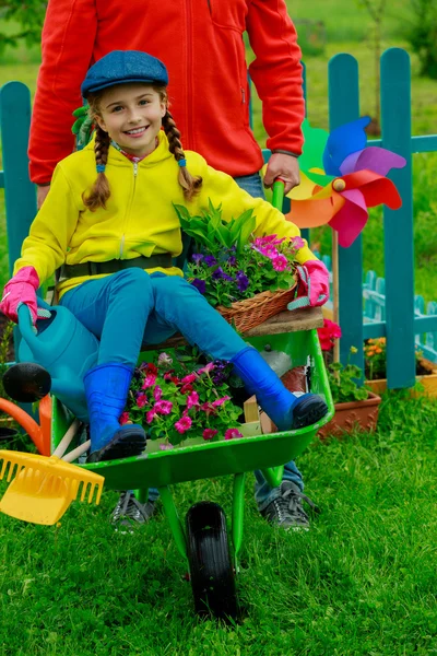 Gardening, planting - girl in barrow helping father — Stock Photo, Image