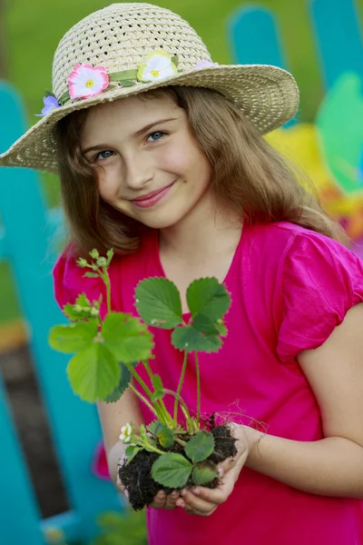 Gardening, planting - lovely girl with strawberry seedling — Stock Photo, Image