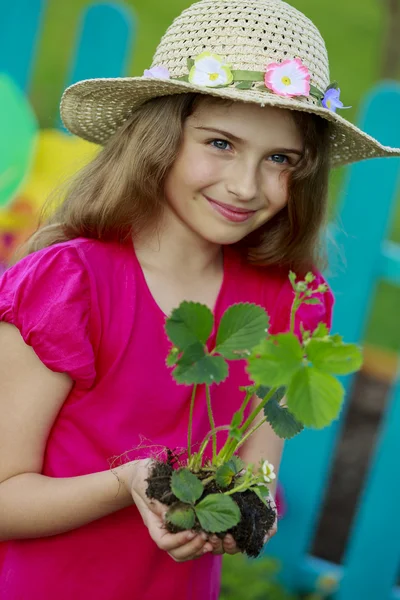 Gärtnern, Pflanzen - hübsches Mädchen mit Erdbeersetzling — Stockfoto