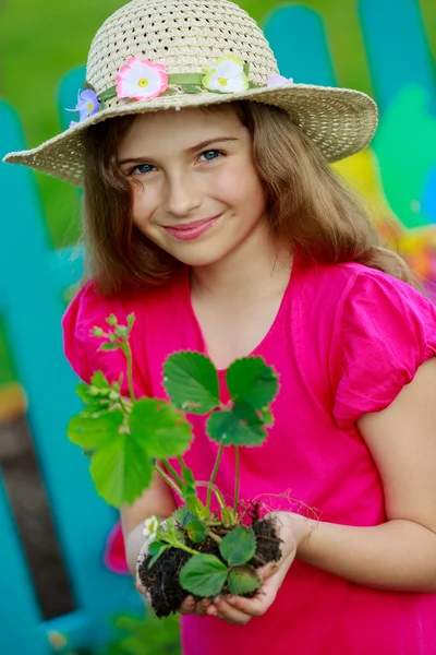 Gärtnern, Pflanzen - hübsches Mädchen mit Erdbeersetzling — Stockfoto