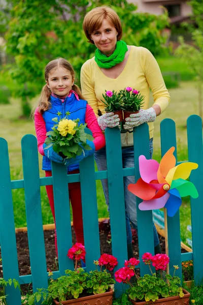 Trädgårdsskötsel - härlig tjej med mor arbetar i blommor trädgård — Stockfoto