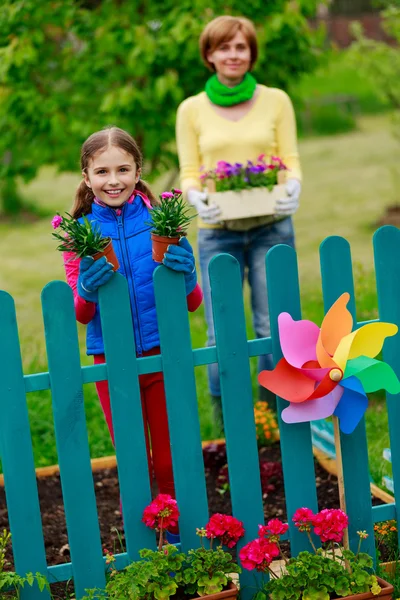 Jardinería - chica encantadora con la madre trabajando en el jardín de flores —  Fotos de Stock