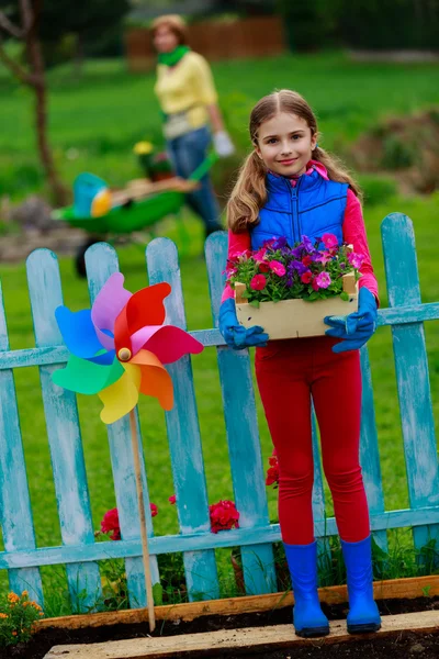 Jardinagem - menina encantadora com a mãe que trabalha no jardim de flores — Fotografia de Stock