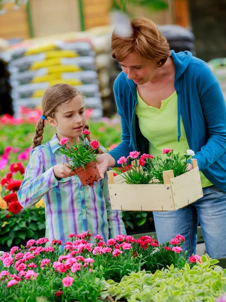 Plantering, trädgård blommor - familjen shopping växter och blommor i garden center — Stockfoto