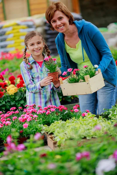 Plantio, flores do jardim - plantas de compras da família e flores no centro do jardim — Fotografia de Stock