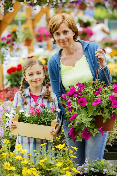 Plantio, flores do jardim - plantas de compras da família e flores no centro do jardim — Fotografia de Stock