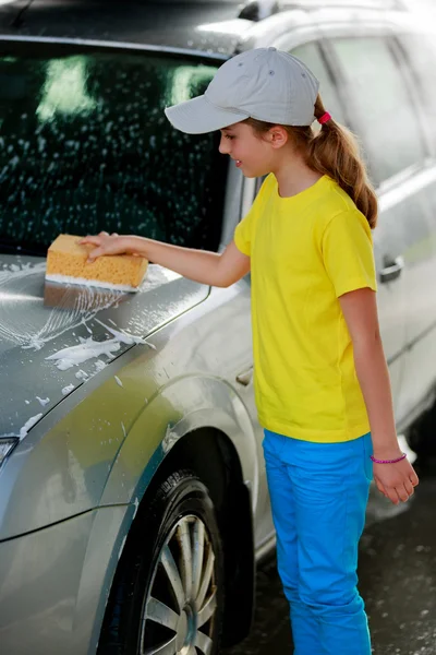 Biltvätt - en tonårsflicka tvättar bilen — Stockfoto