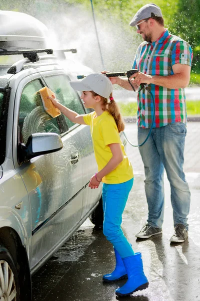 Lavagem de carro - menina ajudando o pai a lavar o carro — Fotografia de Stock