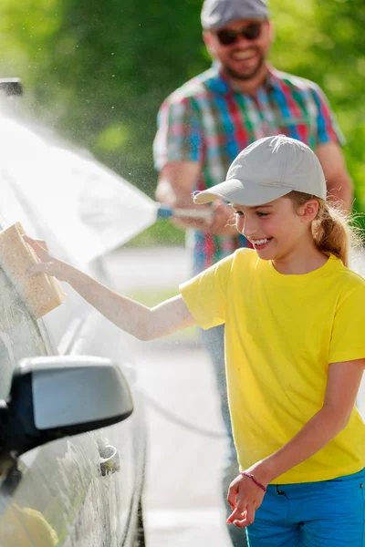 Lavado de coches - niña ayudando a papá a lavar el coche — Foto de Stock
