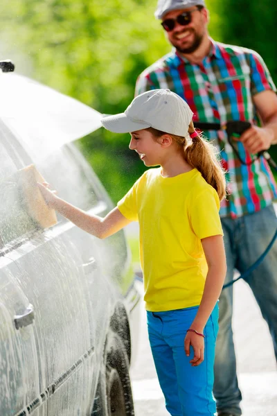 Myčka - mladá dívka pomoc otce umýt auto — Stock fotografie