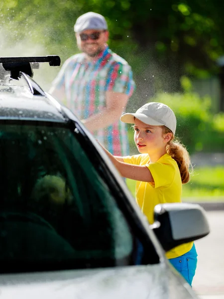 Myčka - mladá dívka pomoc otce umýt auto — Stock fotografie