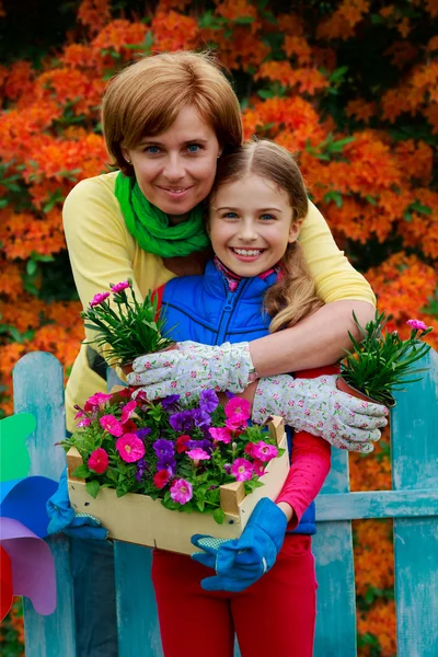 Jardinagem - menina encantadora com a mãe que trabalha no jardim de flores — Fotografia de Stock