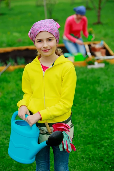 Jardinería - niña ayudando a la madre en el jardín — Foto de Stock