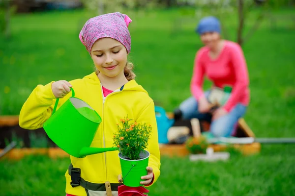 Jardinería - niña ayudando a la madre en el jardín —  Fotos de Stock