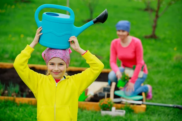 Jardinería - niña ayudando a la madre en el jardín — Foto de Stock