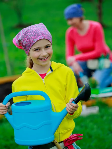 Gardening - girl helping mother in the garden — Stock Photo, Image