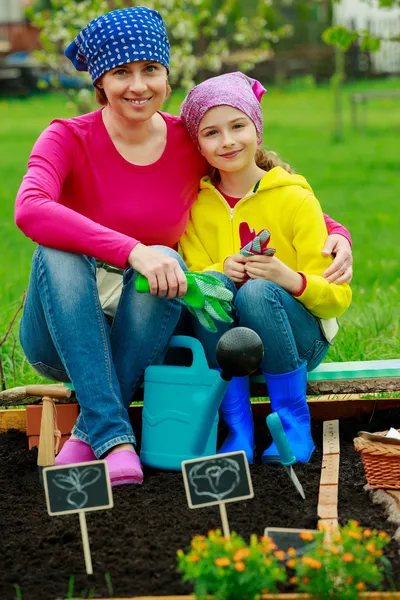 Jardinagem, plantio - menina ajudando a mãe no jardim — Fotografia de Stock