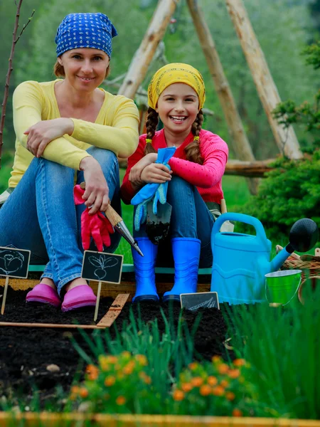 Gärtnern, Pflanzen - Mädchen hilft Mutter im Garten — Stockfoto