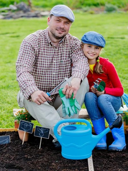 Trädgårdsskötsel, plantering - ung flicka att hjälpa pappa i trädgården — Stockfoto