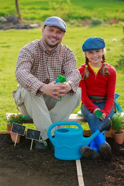 Trädgårdsskötsel, plantering - ung flicka att hjälpa pappa i trädgården — Stockfoto