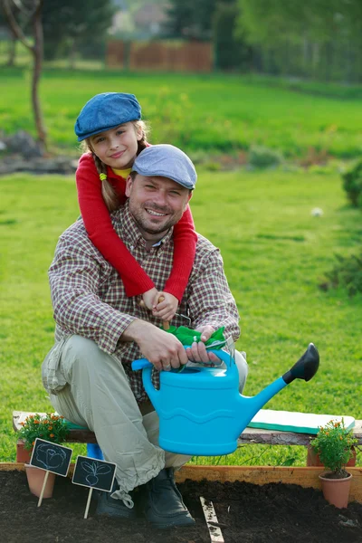 Trädgårdsskötsel, plantering - ung flicka att hjälpa pappa i trädgården — Stockfoto