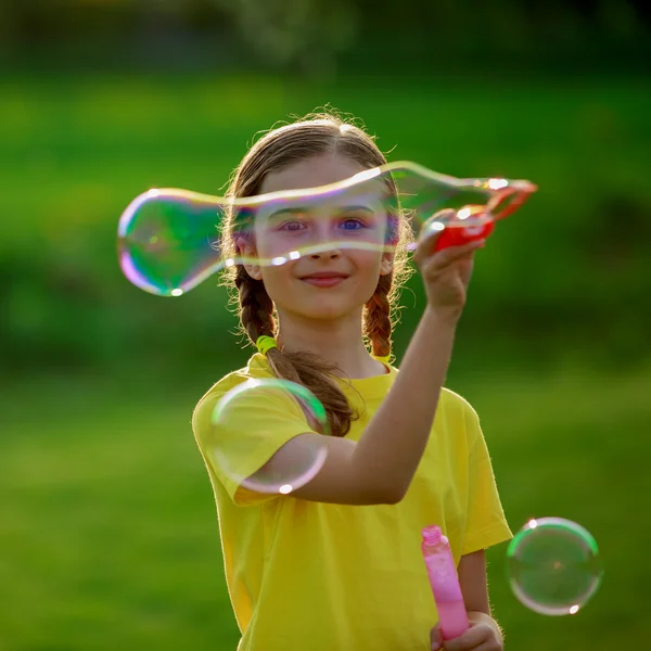 Sommar glädje, unga flicka som leker med såpbubblor — Stockfoto