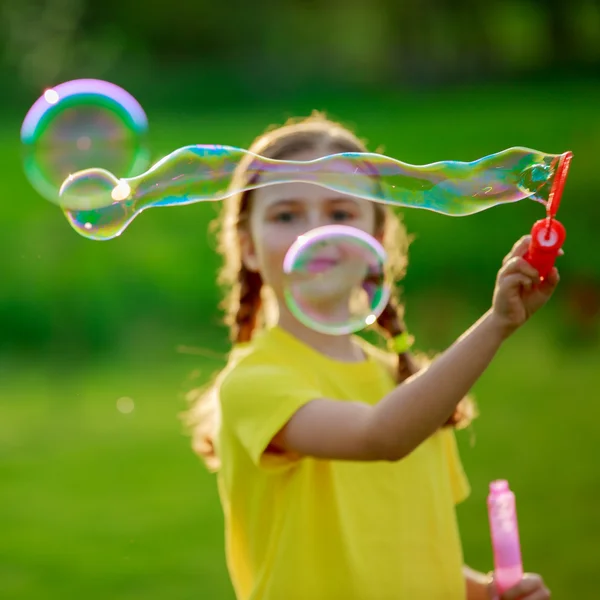 Sommar glädje, unga flicka som leker med såpbubblor — Stockfoto