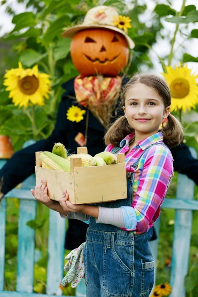 Scarecrow en blij meisje in de tuin — Stockfoto